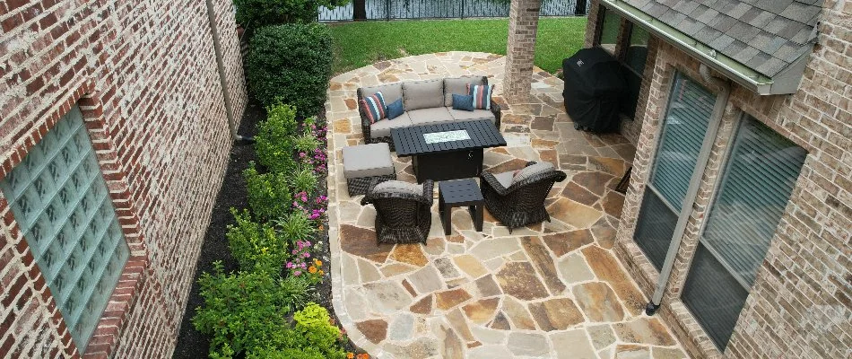 Patio attached to a house in Fort Worth, TX, beside a landscape bed.