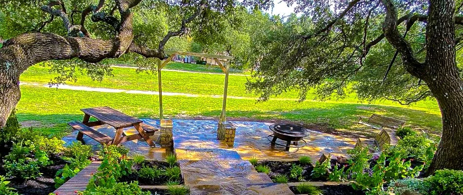 Patio in Fort Worth, TX, under a tree with tables and chairs.