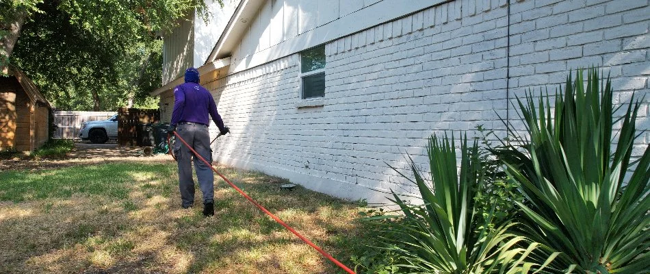 Worker applying a pest control treatment to a lawn in Decatur, TX.