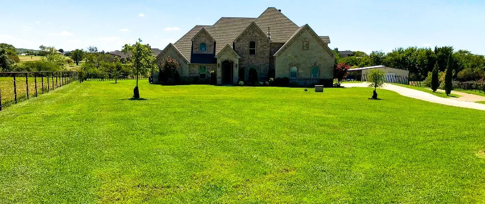 House in Watauga, TX, with large, green lawn.