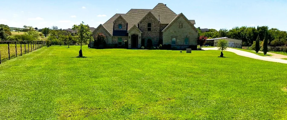 House in Kennedale, TX, with wide, green lawn.