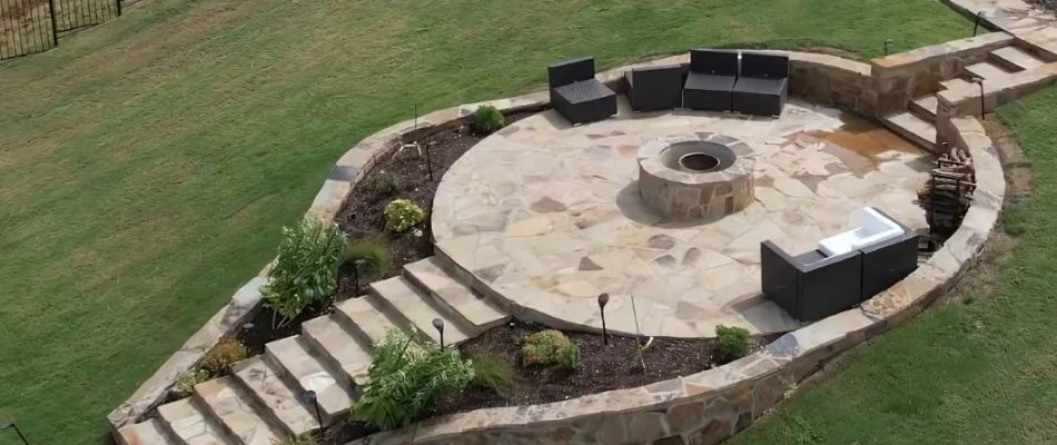 Patio in Fort Worth, TX, with a fire pit, seating walls, and outdoor steps.