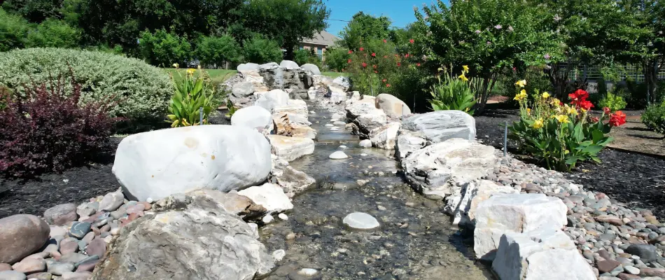 A tranquil scene showcasing a beautifully designed water feature flowing through a landscaped garden.