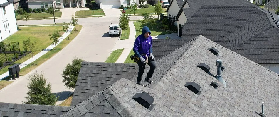 A worker on a roof in Fort Worth, TX, performing a pest exclusion and remediation service.