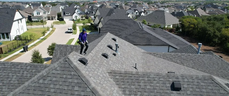 Worker on the roof of a home in Fort Worth, TX, performing a pest exclusion service.